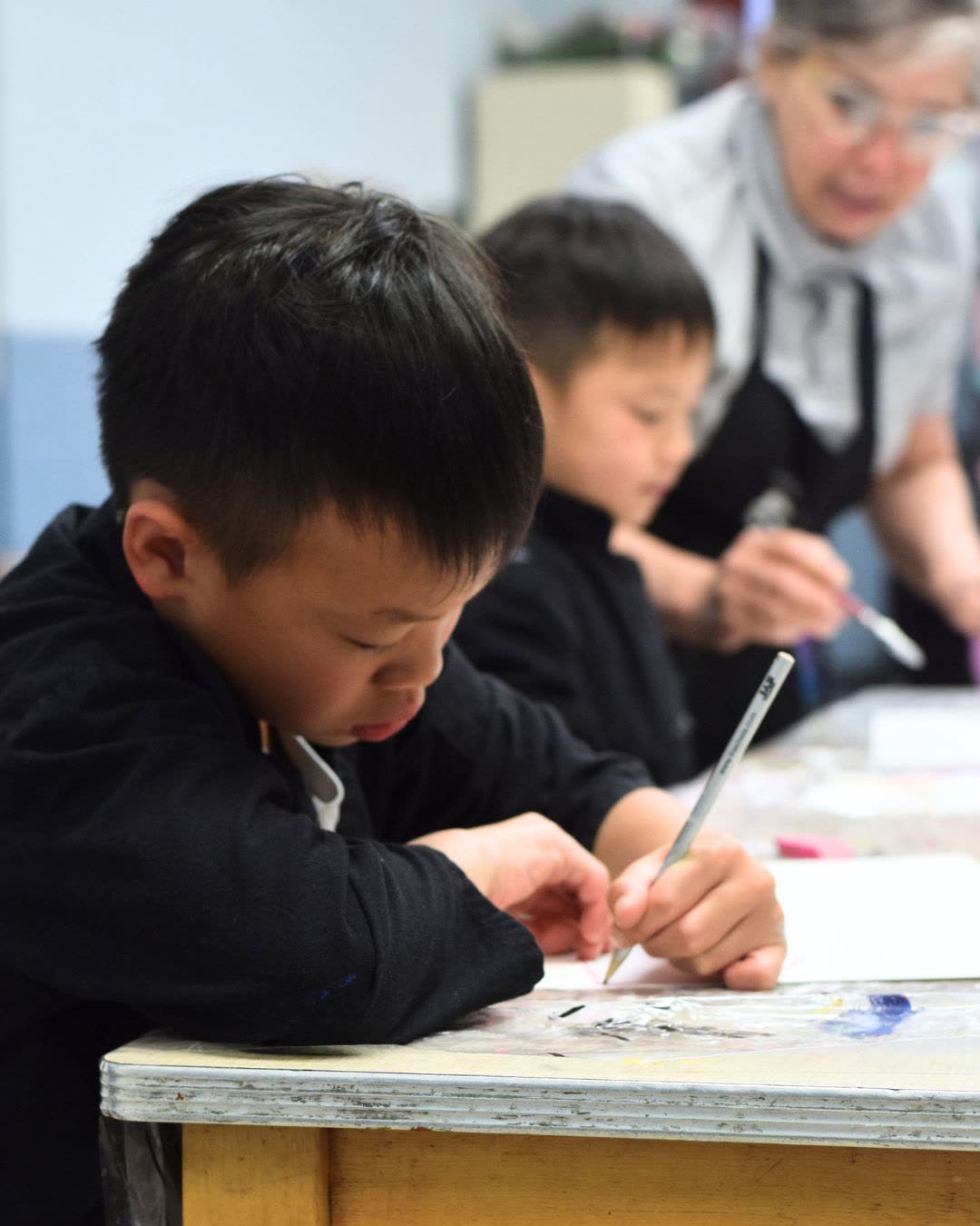 Elite Skills art instructor helping students at the table